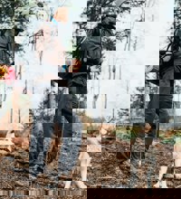 Mand og hund ude på tur i skoven.